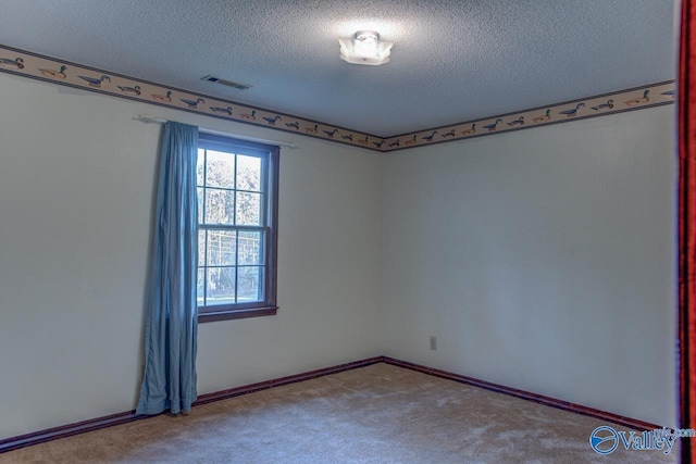 unfurnished room featuring a textured ceiling, carpet floors, visible vents, and baseboards