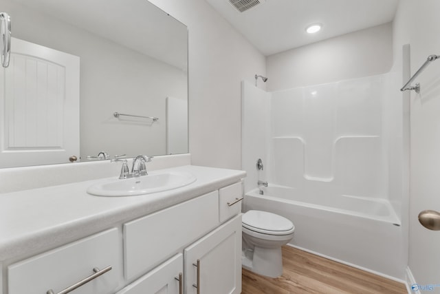 full bathroom featuring vanity, hardwood / wood-style flooring, bathing tub / shower combination, and toilet