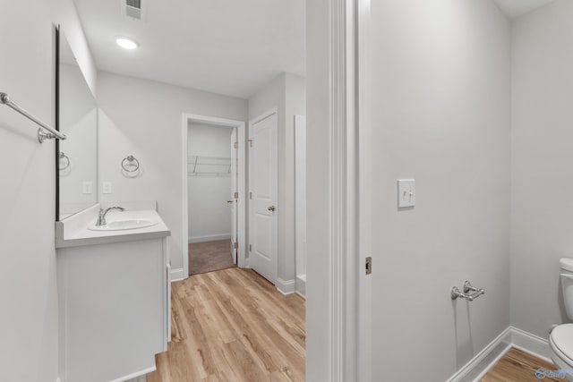 bathroom featuring vanity, toilet, and hardwood / wood-style flooring