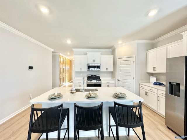 kitchen featuring a sink, crown molding, a breakfast bar, and stainless steel appliances