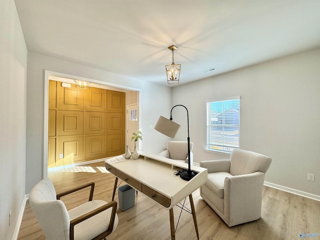 office space with visible vents, baseboards, light wood-style floors, and a chandelier