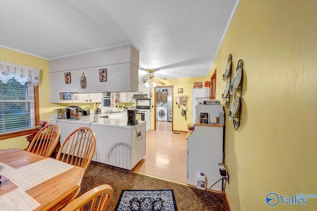 kitchen featuring kitchen peninsula, a textured ceiling, ceiling fan, white cabinetry, and washer / dryer