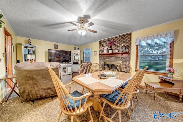 carpeted dining room with a textured ceiling, ceiling fan, and a brick fireplace