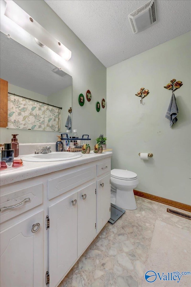 bathroom featuring vanity, a textured ceiling, toilet, and a shower with curtain