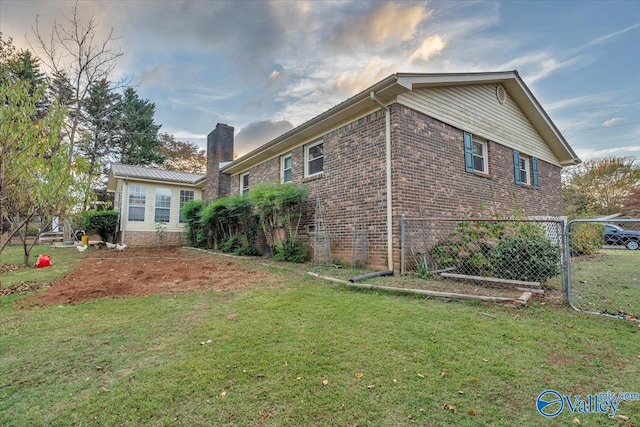 view of side of property with a lawn