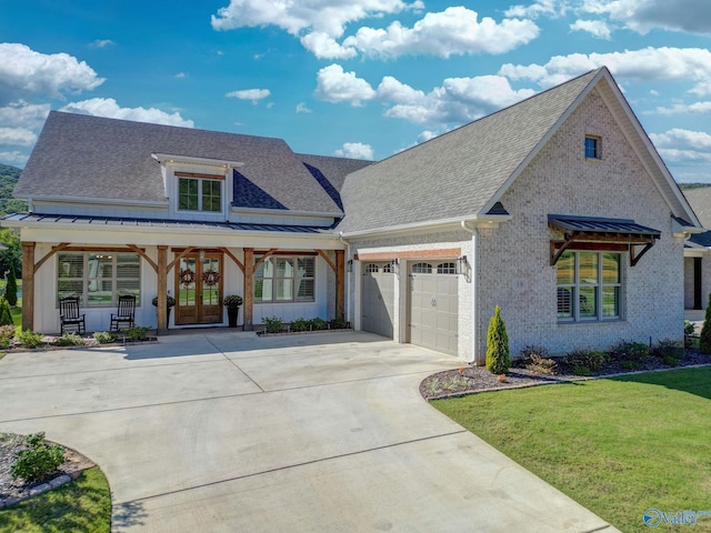 view of front facade featuring an attached garage, a shingled roof, a front lawn, concrete driveway, and french doors