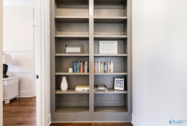 interior details featuring built in shelves, baseboards, and wood finished floors