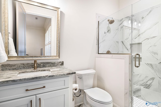 full bath with a marble finish shower, ornamental molding, vanity, and toilet