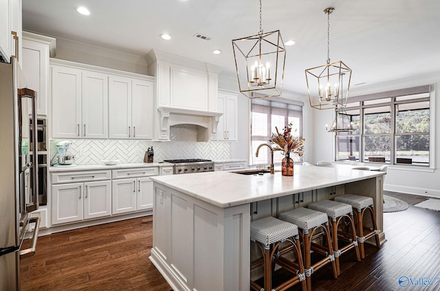kitchen with white cabinets, a chandelier, visible vents, and a sink