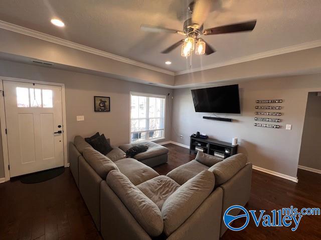 living room featuring crown molding, dark hardwood / wood-style floors, and a healthy amount of sunlight