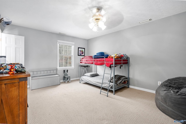 carpeted bedroom featuring a ceiling fan, visible vents, and baseboards