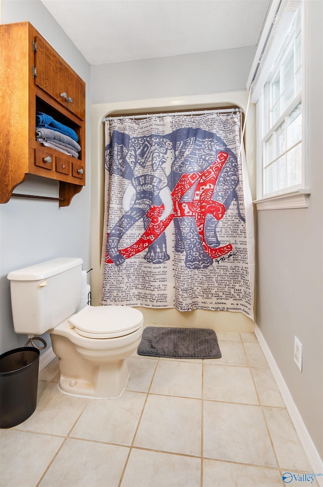 full bathroom with a shower with shower curtain, tile patterned flooring, toilet, and baseboards