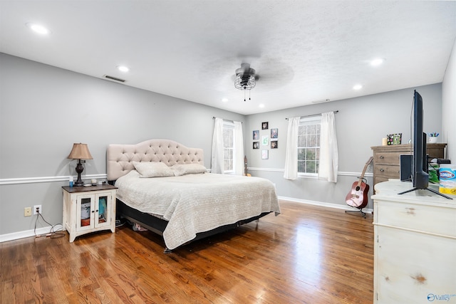 bedroom featuring ceiling fan, recessed lighting, wood finished floors, visible vents, and baseboards