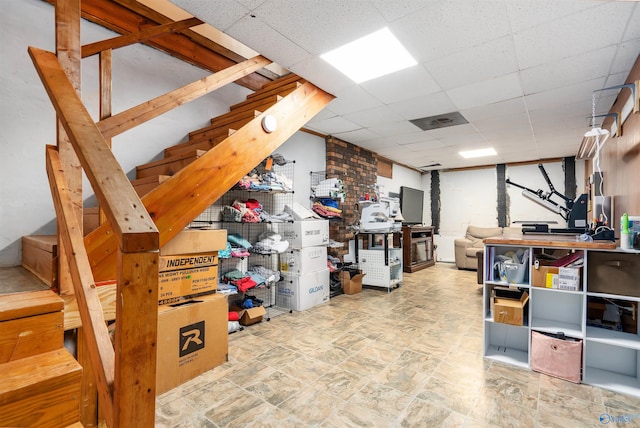 finished basement featuring stairs and a drop ceiling