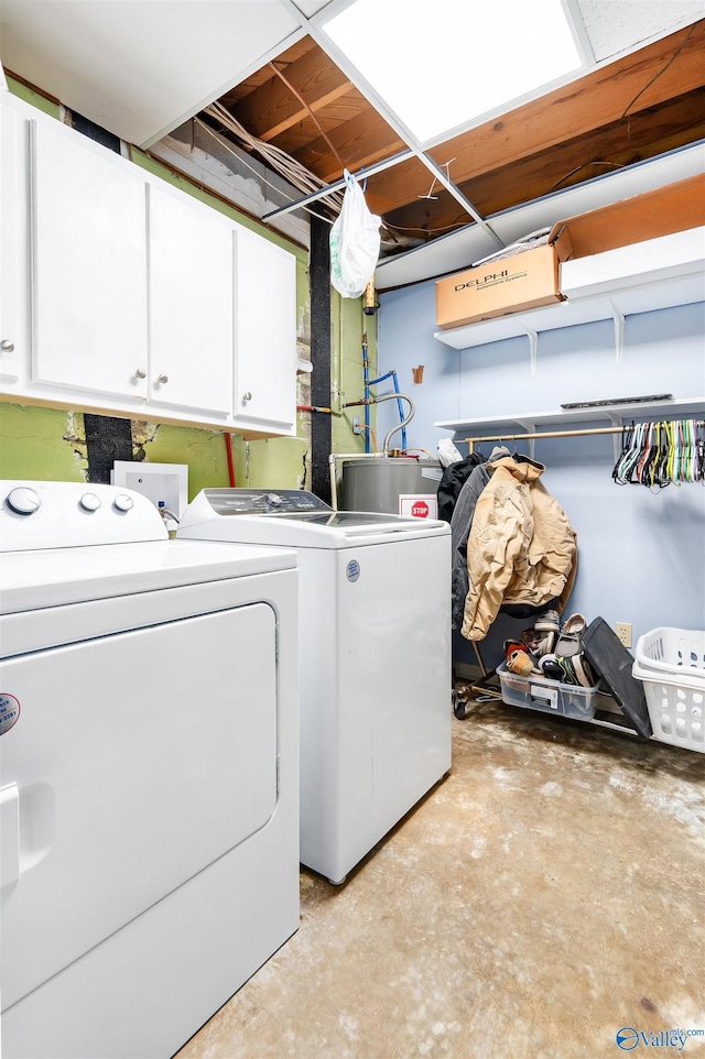 washroom with water heater, cabinet space, and washing machine and clothes dryer