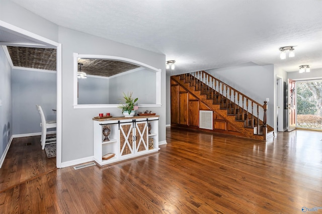 interior space featuring visible vents, dark wood finished floors, stairway, and baseboards