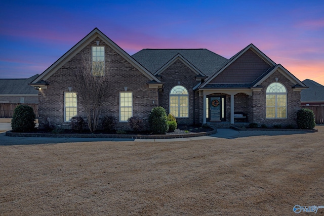 view of front of house with fence and brick siding