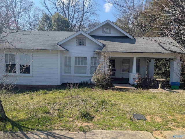 view of front facade featuring a porch, a front yard, and a shingled roof