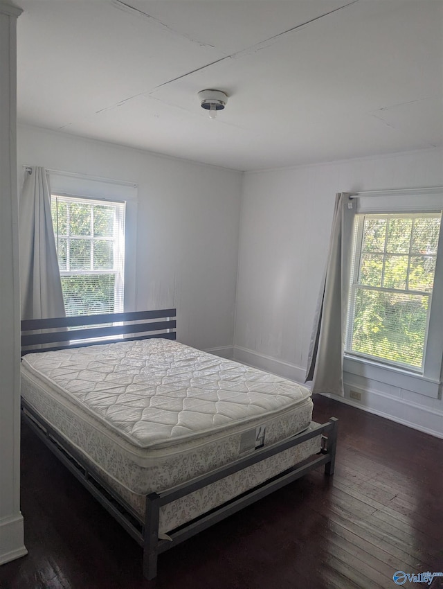 bedroom with multiple windows, baseboards, and dark wood-style flooring