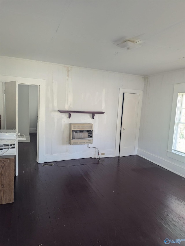 unfurnished living room featuring heating unit, visible vents, baseboards, and dark wood-style flooring