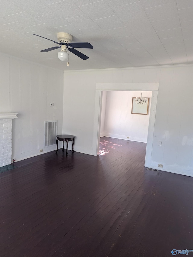 spare room with dark wood-style floors, visible vents, and ceiling fan with notable chandelier