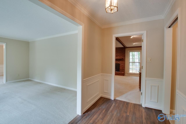 2703 Box Canyon Rd SE, Huntsville, AL 35803 - hallway with dark wood-style flooring, crown molding, wainscoting, a chandelier, and a textured ceiling