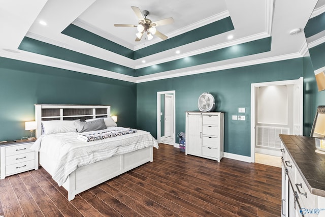 bedroom with crown molding, dark wood-type flooring, a raised ceiling, and ceiling fan