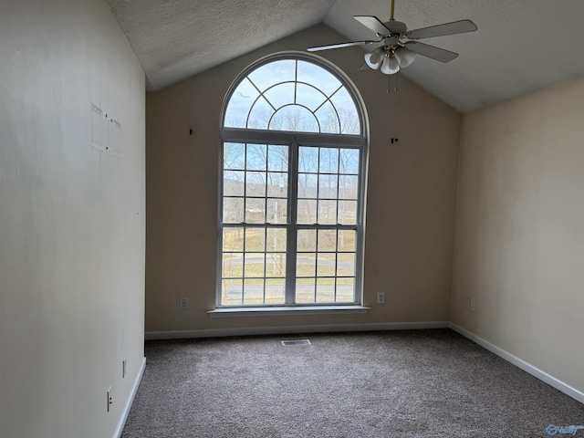 carpeted spare room with visible vents, vaulted ceiling, a textured ceiling, and baseboards