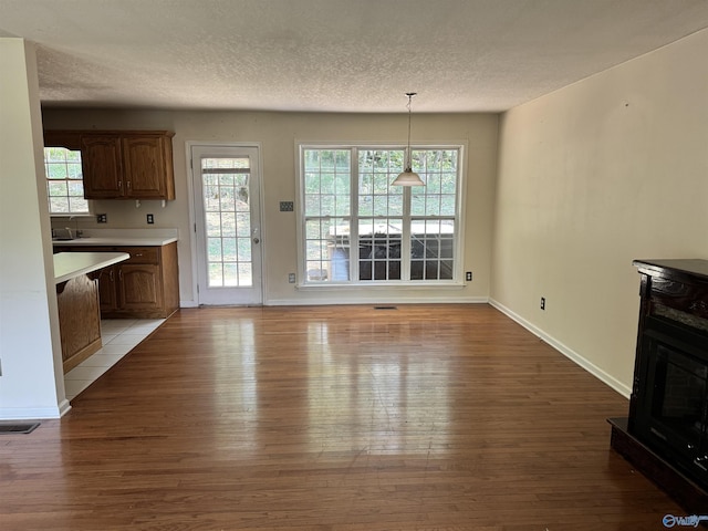 unfurnished dining area featuring light wood finished floors, visible vents, and a healthy amount of sunlight