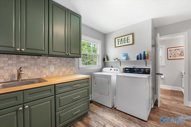 1762 Old Big Cove Rd SE, Owens Cross Roads, AL 35763 - laundry room with wood finished floors, a sink, cabinet space, and washer and clothes dryer
