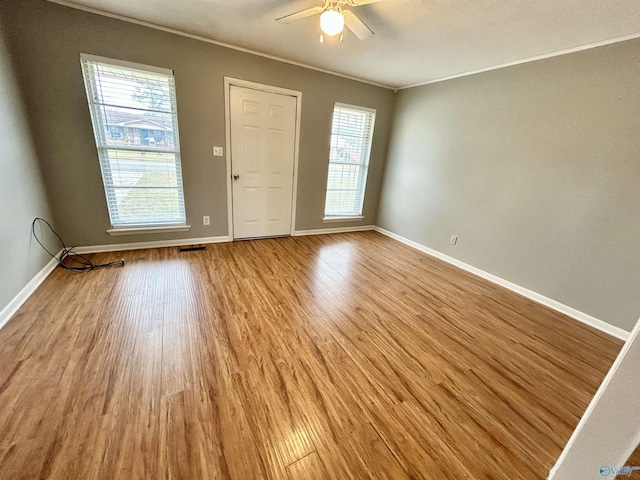 empty room with crown molding, ceiling fan, and light hardwood / wood-style flooring