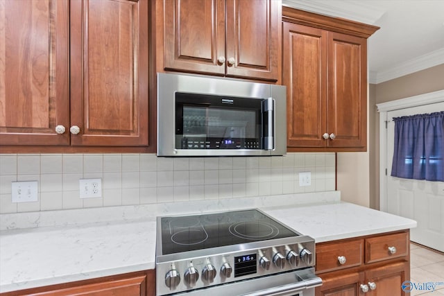 kitchen featuring light stone counters, ornamental molding, decorative backsplash, and stainless steel appliances
