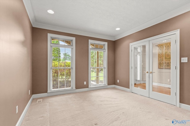 carpeted empty room with french doors, ornamental molding, and baseboards