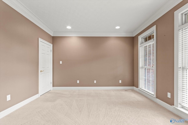 spare room with crown molding, recessed lighting, baseboards, and light colored carpet