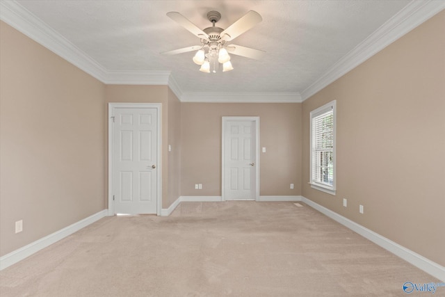 interior space with baseboards, ornamental molding, a ceiling fan, and light carpet