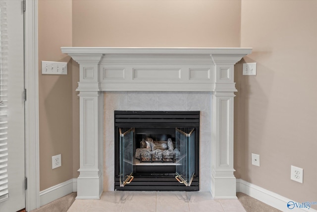 interior details featuring baseboards and a tiled fireplace