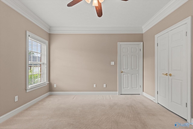 unfurnished bedroom featuring carpet floors, baseboards, ornamental molding, and ceiling fan