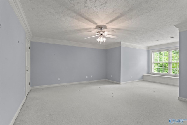 spare room featuring carpet floors, a ceiling fan, baseboards, and crown molding