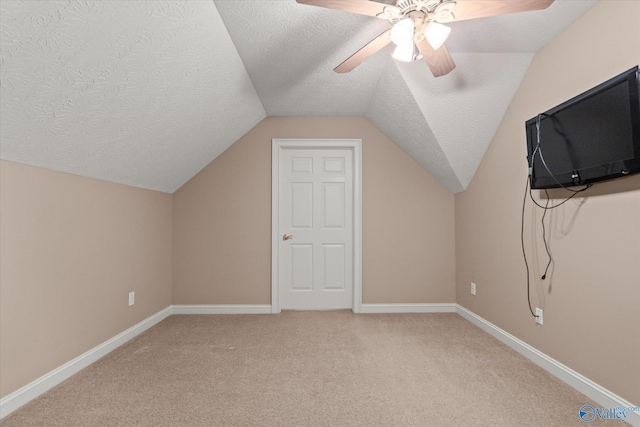 bonus room featuring ceiling fan, lofted ceiling, a textured ceiling, and light colored carpet
