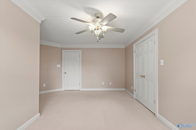 empty room with crown molding, ceiling fan, light carpet, and baseboards