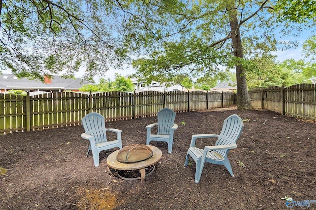 view of yard featuring a fenced backyard and a fire pit