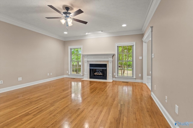 unfurnished living room with ceiling fan, a healthy amount of sunlight, and light wood-type flooring