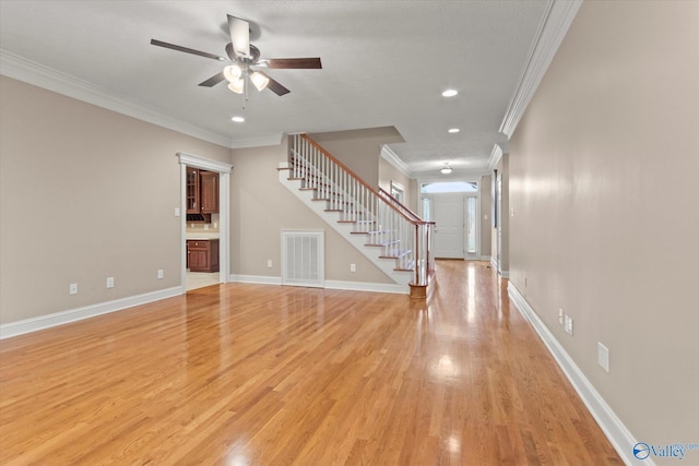 unfurnished living room with visible vents, ornamental molding, stairs, and ceiling fan