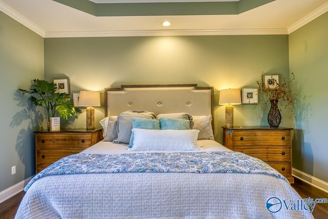 bedroom with a tray ceiling, ornamental molding, and dark hardwood / wood-style flooring