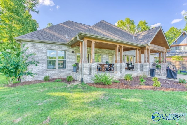 rear view of property featuring a lawn