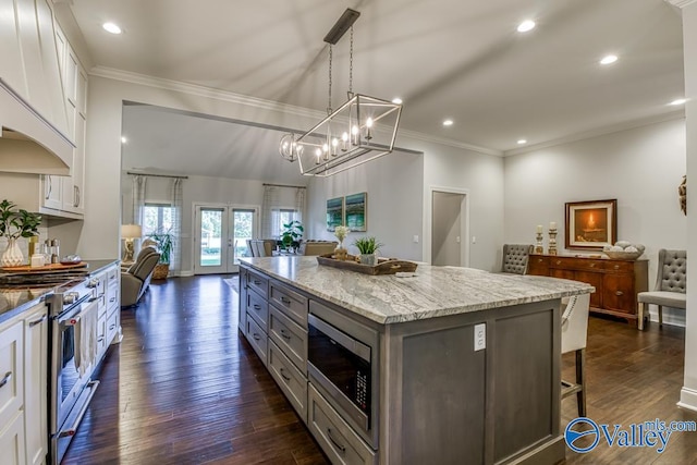 kitchen with white cabinets, a center island, dark hardwood / wood-style floors, and stainless steel appliances