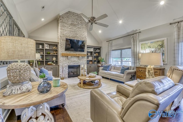 living room with high vaulted ceiling, ceiling fan, hardwood / wood-style floors, and a brick fireplace