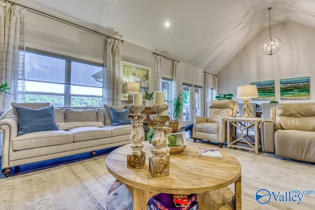 living room with a chandelier and lofted ceiling