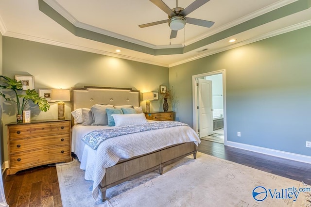 bedroom featuring hardwood / wood-style flooring, a raised ceiling, and crown molding