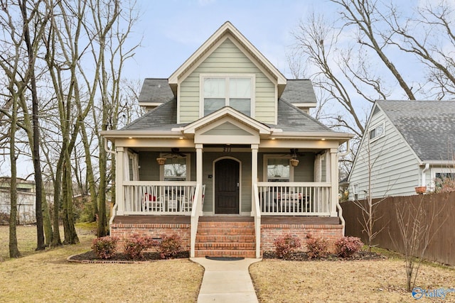 bungalow-style home with covered porch and a front lawn